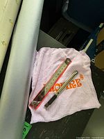 Close view of silver roll, utility knife on pink cloth