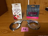 Front view of Sexy Santa Says card box, Bedroom Commands card box, and metal handcuffs