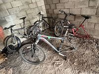 Multiple bicycles leaning against concrete wall