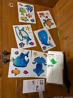 Sticker sheets with colourful marine designs, clear bag with white grips, instruction leaflet, and rolled BJÄRSEN shower curtain