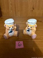 Front view of both ceramic bear chef shakers