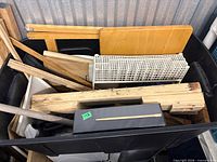 Tote filled with wood pieces, plastic grid, box visible