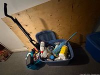 Blue bin filled with cleaning supplies next to teal caddy