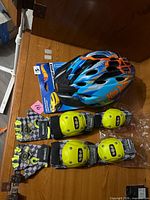 Helmet, knee pads, gloves displayed on wood surface