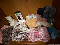 Overall view of all folded curtains, pillowcases, throws and packaged item on wooden surface