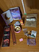 Group shot showing book lock box, smudge stick, incense, burner, bowl, tin and crystals