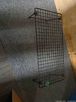 Overall view of black metal wire rack with legs extended