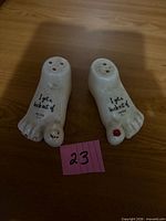 Pair of foot-shaped shakers front view showing text and toe detail