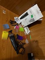 All components laid out: clipper, comb guards, clips, brush, oil, box