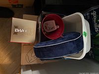 Top view showing neck pillow, red bucket, white bin