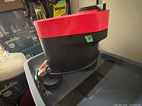 Side view of Nespresso red coffee machine showing power cord and housing