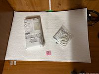 Bath mat with packaged shower curtain and hooks displayed