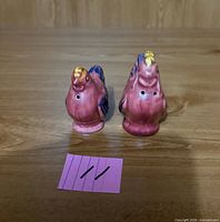 Front view of rooster and hen shakers showing color and pour holes