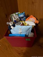 Red bin filled with assorted cleaning products