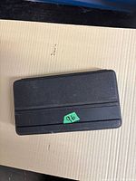 Closed black plastic case with green label