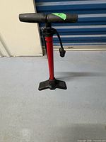 Full view of red floor pump standing upright