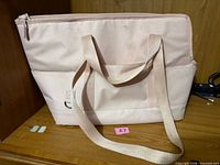 Front view of light pink Top Paw carrier showing zip closure and handles