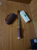 Telescope fully extended beside carrying case and box