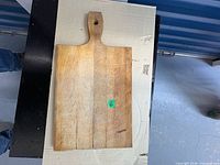 Front view of rectangular wooden cutting board with handle