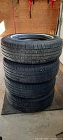 Stack of four Uniroyal P235/75R15XL tires showing tread and whitewall