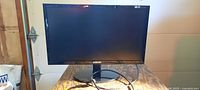 Front view of Samsung SyncMaster E2220X monitor on stand with power cable