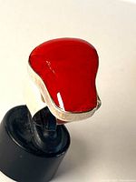 Front view of red coral sterling silver ring on display stand