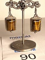 front view of sterling silver tiger eye dangle earrings on stand