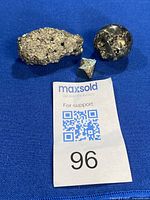 All three pyrite specimens on blue cloth with auction tag