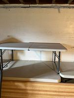 Two low folding tables set up side by side showing tops and legs