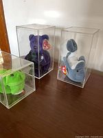 All three Beanie Babies in acrylic cases on table