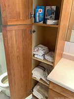 Cabinet with towels, blood pressure monitor box on shelf