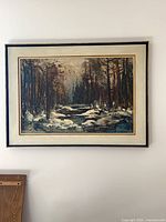 Front view of framed oil painting depicting winter forest stream
