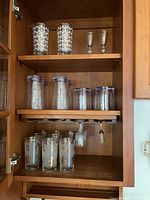 Cupboard showing all three shelves of assorted drinkware
