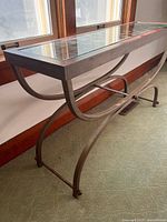 Side angle showing full table structure, curved legs and glass top