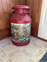 Front of red metal milk can with painted deer scene