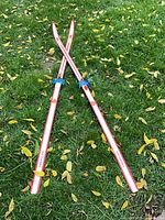 Full view of crossed skis on grass