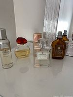 Group shot of five perfume bottles on dresser