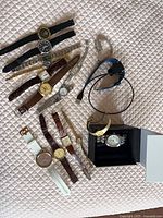 Overview of all wristwatches and Citizen watch in box on quilted surface