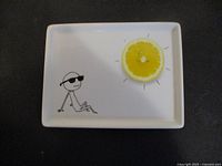 Top view of white appetizer plate with stick figure and lemon slice design