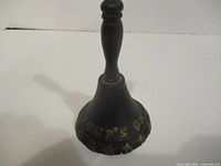 Front view of black cast iron hand bell