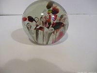 Front view of clear glass paperweight showing internal coloured design