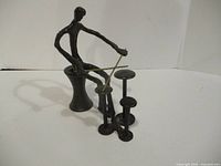 front view of metal drummer sculpture showing figure, drums, sticks