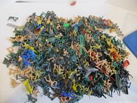 Pile of mixed plastic soldiers, cowboys, animals, accessories, jet plane visible
