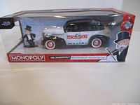 Front view of boxed Monopoly 1939 Chevrolet die-cast car with included Mr. Monopoly figure