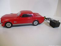 Red Mustang VHS rewinder side profile with AC adapter