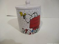 Front view of cookie jar showing Snoopy on doghouse graphic