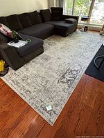 Full view of rug in living room showing overall design and size relative to sectional sofa