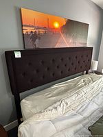 Full view of tufted upholstered headboard attached to bed frame