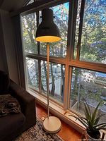 Full view of white floor lamp by window