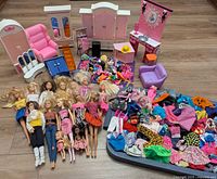 Overall lot showing dolls, furniture, large pile of clothing and accessories